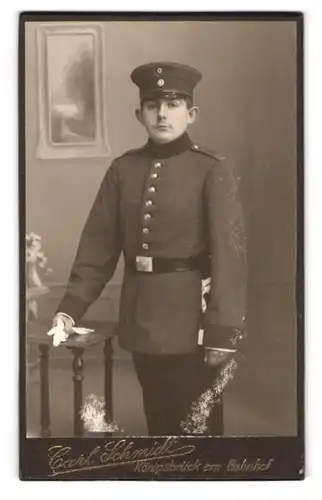 Fotografie Carl Schmidt, Königsbrück, am Bahnhof, Portrait junger Soldat in Uniform mit Schirmmütze