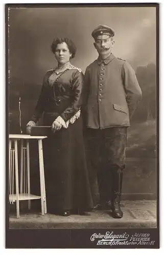 Fotografie Atelier Elegant, Berlin, Frankfurter Allee 56, Soldat in feldgrauer Uniform mit Schirmkappe