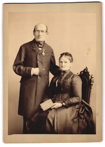 Fotografie unbekannter Fotograf und Ort, Veteran mit Brille und Orden mit seiner Frau