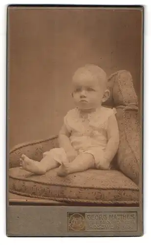 Fotografie Georg Matthes, Rosswein, Mittelstrasse 17, Baby mit traurigem Gesicht im Sessel