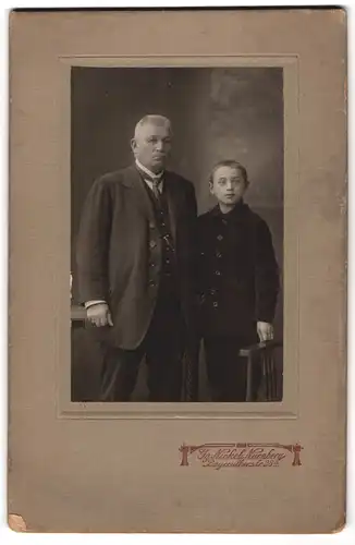 Fotografie Gg. Nickel, Nürnberg, Bayreutherstr. 28, Vater mit seinem Sohn in Anzügen posieren im Atelier