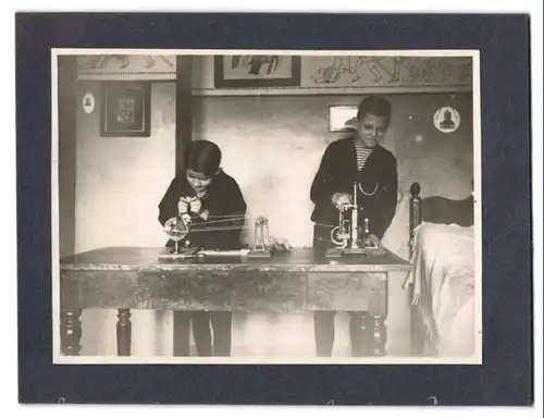 Fotografie unbekannter Fotograf und Ort, zwei Knaben an ihrer Modellbau Dampfmaschine, Blechspielzeug