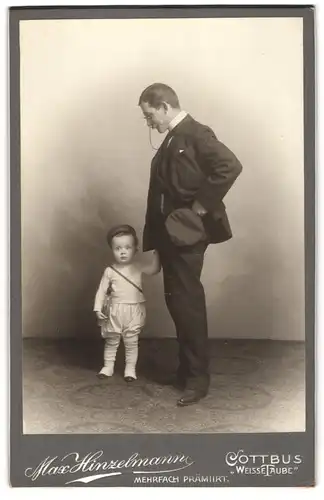 Fotografie Max Hinzelmann, Cottbus, junger Vater mit seinem Sohn samt Nuckelflasche im Armt posieren im Atelier