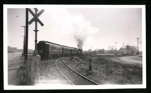 Fotografie Eisenbahn USA, Personenzug mit Dampflok hat soeben einen Bahnübergang passiert