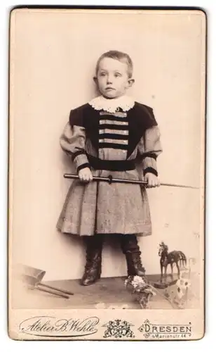 Fotografie B. Wehle, Dresden, Marienstr. 44, Kleiner Junge im Kleid mit Spielzeugpferd
