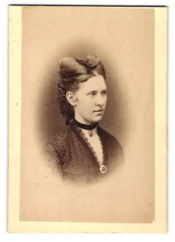 Fotografie Dr. A. Bussenius, Stade, Portrait junge Dame im dunklen Kleid mit Brosche und Haarschmuck
