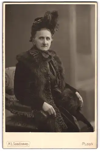 Fotografie K. L. Sobehrad, Plzen, ältere Dame im Pelzmantel mit Federhut, 1913