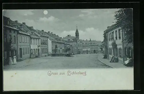 Mondschein-AK Lichtenberg, Strassenpartie mit Geschäften und Brunnen