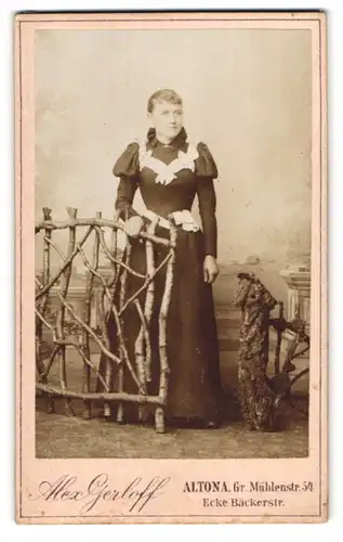 Fotografie Alex Gerloff, Altona, Gr. Mühlenstr. 54, Portrait junge Frau im gerüschten Kleid am Holzzaun stehend