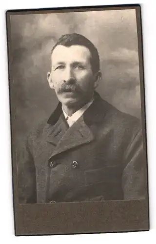 Fotografie unbekannter Fotograf und Ort, Mann mit Schnurrbart im Mantel