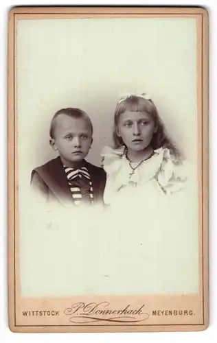 Fotografie P. Donnerhack, Wittstock, Kleiner Junge im Matrosenhemd und Mädchen im Kleid mit Kreuzkette