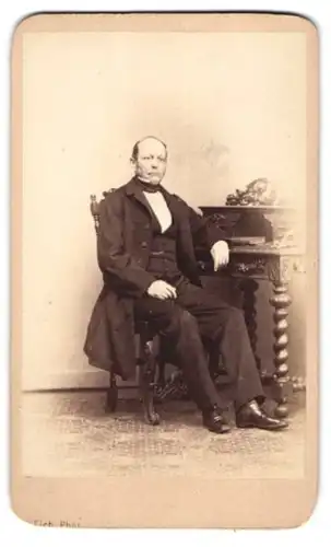 Fotografie R. Eich, Dresden, Pragerstr. 39, Herr im Anzug mit halbglatze sitzt am Sekretär