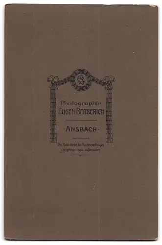 Fotografie Eugen Berberich, Ansbach, Grosser Mann im edlen Kostüm neben einem Holztisch posierend