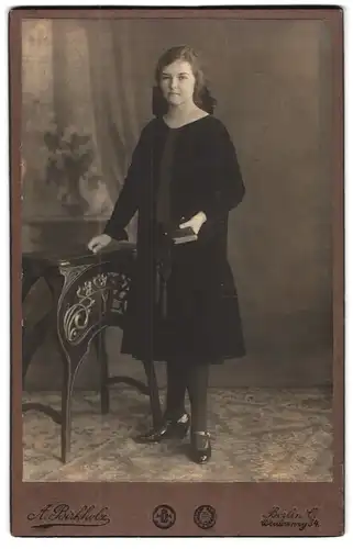Fotografie A. Birkholz, Berlin, Weidenweg 34, Junge Frau in schwarzem Gewand und Bibel in der Hand