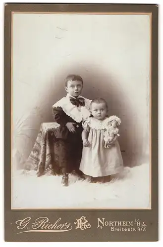 Fotografie G. Richers, Northeim i. Hs., Breitestrasse 477, Kleiner Junge und kleines Mädchen mit Puppe