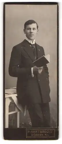 Fotografie P. Hartbrecht, Döbern /N.-L., Junger Herr im Anzug mit einem Buch