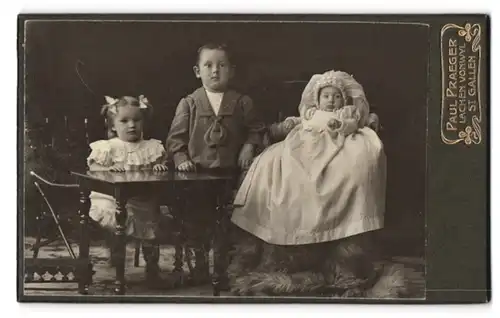 Fotografie Paul Praeger, Lachen, Zwei festlich gekleidete Kinder mit Täufling