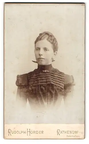 Fotografie Rudolph Hörder, Rathenow, Bahnhofstrasse, Junge Dame in einem schwarzen, verzierten Kleid