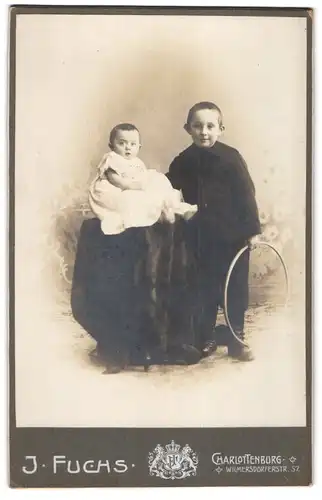 Fotografie J. Fuchs, Charlottenburg, Wilmersdorferstrasse 57, Knabe mit Reifen und Baby im Taufkleid