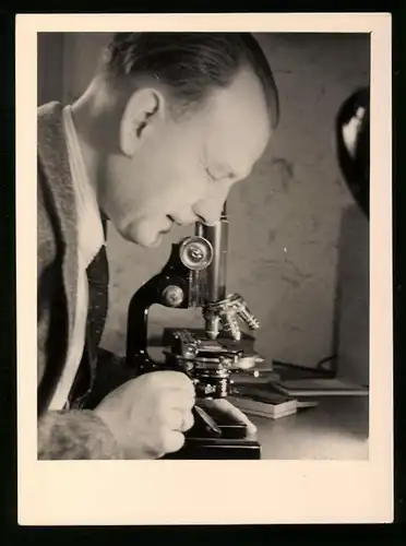 Fotografie Chemiker mit Mikroskop bei der Untersuchung einer Probe