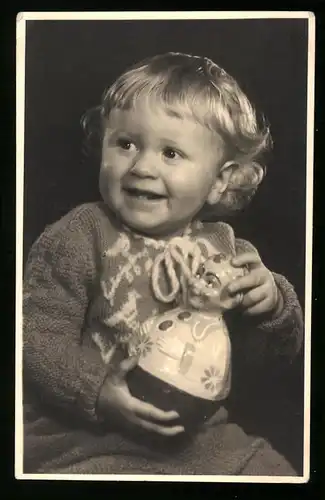 Fotografie Fischer, Berlin-Lichtenberg, glückliches Baby mit Spielzeug-Figur