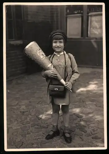 Fotografie Einschulung, glückliches Mädchen mit Zuckertüte am ersten Schultag