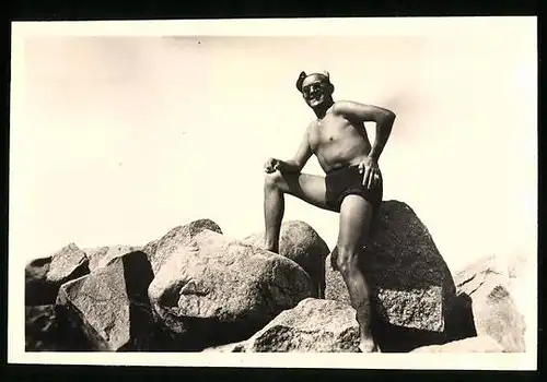 Fotografie Strandmeister in Badehose auf einem Wellenbrecher