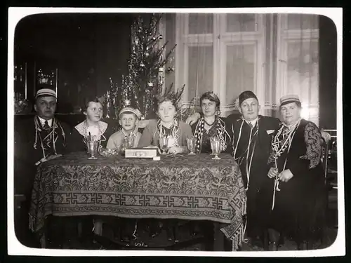 Fotografie Weihnachtsfeier, Familie sitzt gemeinsam am Weihnachtsbaum