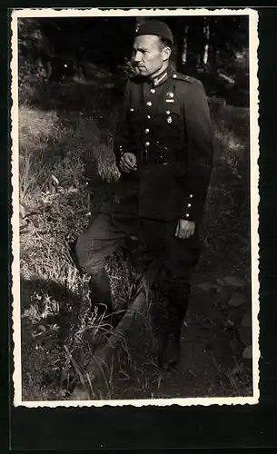 Foto-AK Lettischer Soldat in Uniform im Wald eine Zigarette rauchend