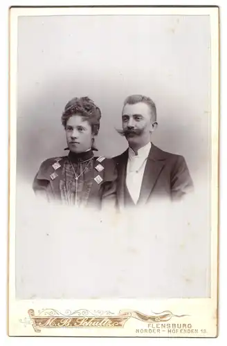 Fotografie M. B. Schultz, Flensburg, Norder-Hofenden 13, Junger Herr mit ausgeprägtem Schnauzer nebst Ehefrau
