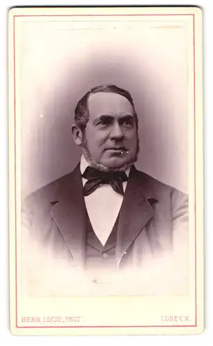 Fotografie Herm. Linde, Lübeck, Johannisstr. 31, Älterer Herr im Anzug mit Chin-Strap