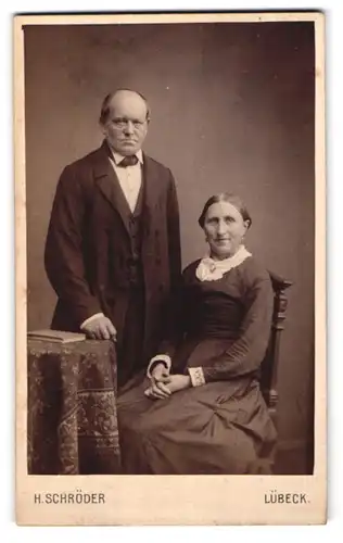 Fotografie H. Schröder, Lübeck, Beckergrube 150, Älteres Paar in hübscher Kleidung