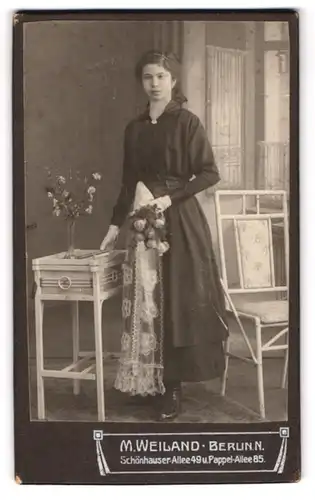 Fotografie M. Weiland, Berlin, Schönhauser-Allee 49, Portrait junge Frau im dunklen Kommunionskleid mit Blumenstrauss