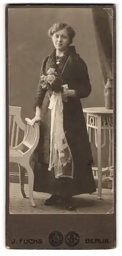 Fotografie J. Fuchs, Berlin, Portrait junge Frau im dunklen Kleid zur Kommunion, Blumenstrauss in der Hand