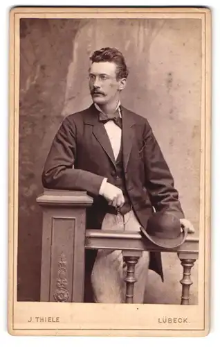 Fotografie Jul. Thiele, Lübeck, Gr. Burgstr. 615, Junger Herr in Anzugjacke mit Brille und Schnauzbart