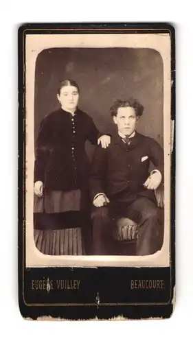 Fotografie Eugène Vuilley, Beaucourt, Junge Frau mit Mittelscheitel und junger Mann mit Locken im Sonntagsstaat