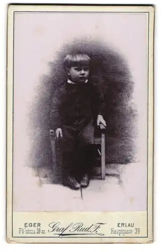 Fotografie Graf Rud. F., Erlau, Hauptgasse 39, Portrait kleiner Bube sitzt im Anzug auf einem Stuhl