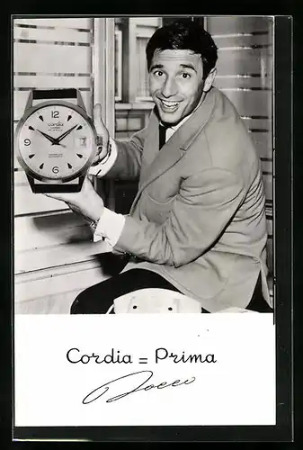AK Cordia-Prima, Mann zeigt eine übergrosse Uhr in die Kamera