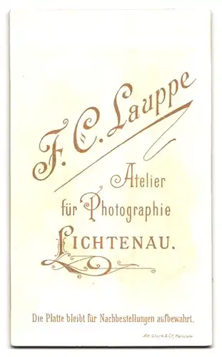 Fotografie F. C. Lauppe, Lichtenau, Süsses Kleinkind im Kleid sitzt auf Fell
