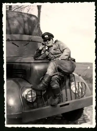 Fotografie Lastwagen Phänomen Granit 30K, Soldat der NVA liegt auf der Motorhaube