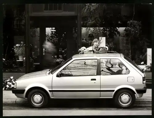 Fotografie Auto Nissan Micra, Kleinwagen vor einem Blumenladen, Rückseitig technische Daten