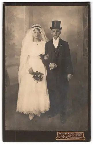 Fotografie H. Buddruss, Berlin, Steifensandstr. 5, Eheleute im Hochzeitskleid und Anzug mit Zylinder, Brautstrauss