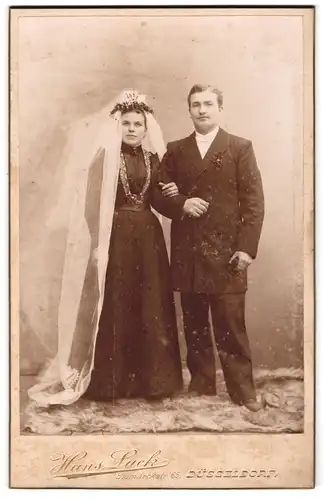 Fotografie Hans Luck, Düsseldorf, Bismarckstr. 65, Eheleute im schwarzen Hochzeitskleid und Anzug mit Schleier