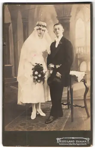 Fotografie M. Weiland, Berlin, Schönhauser Allee 49, sehr junges Brautpaar im Hochzeitskleid und Anzug mit Zylinder