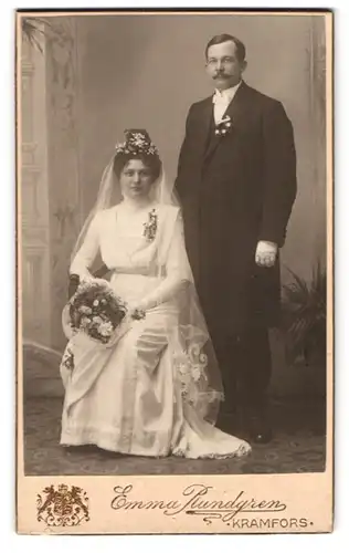 Fotografie Emma Rundgren, Kramfors, schwedisches Brautpaar im Brautkleid mit Strauss und Schleier, dunkler Anzug