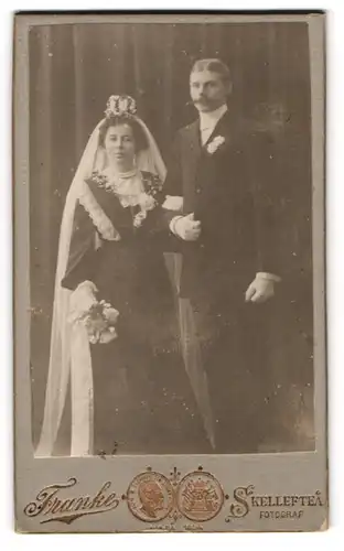 Fotografie Franke, Skelleftea, Brautpaar im schwarzen Hochzeitskleid und Anzug posieren mit Brautstrauss