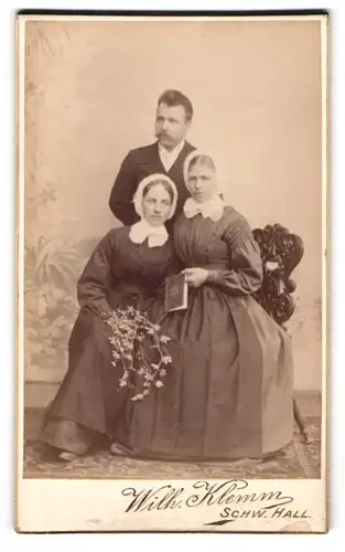Fotografie Wilh. Klemm, Schwäbisch Hall, Portrait Herr mit zwei Damen in Biedermeierkleidern und Haube
