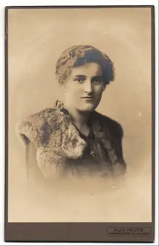 Fotografie Aug. Nolte, Hannover, Holzmarkt 6, Portrait junge Frau im Kleid mit Pelzkragen und Jugendstil Frisur