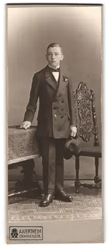 Fotografie A. Wertheim, Berlin, Oranienstr., Portrait junger Knabe im Anzug mit Hut zur Konfirmation