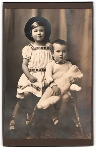 Fotografie unbekannter Fotograf und Ort, Portrait zwei niedliche Kinder mit ihrem grossen Teddybär im Arm